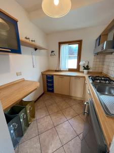 a kitchen with a sink and a stove top oven at Dolomitihouse AUNER in Fiera di Primiero