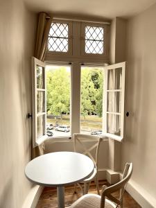 een tafel en stoelen voor een raam bij Les Suites de la Tour d'Embas in Vitré