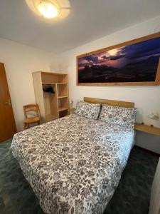 a bedroom with a bed with a black and white comforter at Dolomitihouse AUNER in Fiera di Primiero