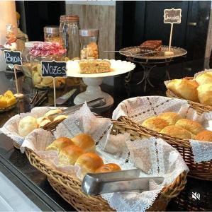 a bakery with baskets of bread and pastries on display at AVENIDA HOTEL DE RESENDE in Resende