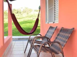 dwa krzesła i hamak na ganku w obiekcie O Recanto Pousada w mieście Serra Negra