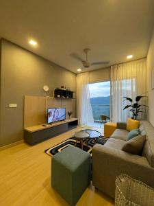 a living room with a couch and a tv at Kincir Homesuites - Free WiFi & Netflix in Genting Highlands