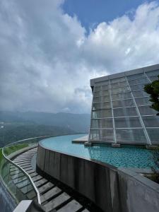 a building with a swimming pool in front of it at Kincir Homesuites - Free WiFi & Netflix in Genting Highlands