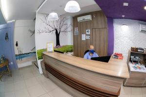 a man sitting at a counter in a store at Aeroporto Plaza Hotel in Campo Grande