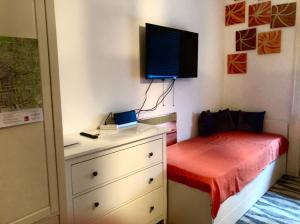 1 dormitorio con 1 cama y vestidor con TV en la pared en Wiesbaden Mitte, en Wiesbaden