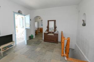 uma sala de estar com televisão e espelho em Astraia em Agios Ioannis