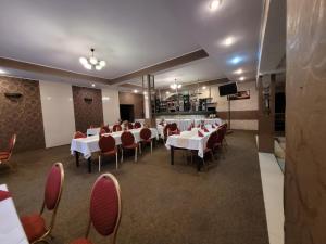 a restaurant with white tables and red chairs at Hotel i Restauracja „KRISTAL” in Braniewo