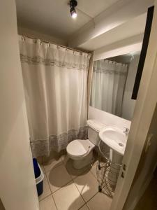 a bathroom with a toilet and a sink at Departamento Vistamar 4 puertas del pacifico in Arica +23 photos