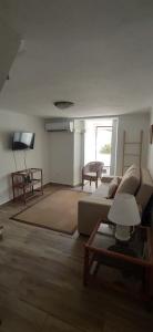 een woonkamer met een bank en een flatscreen-tv bij Casa da Portagem by Portus Alacer in Marvão