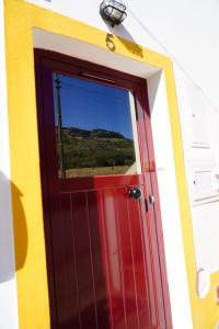 eine rote Tür mit einem Fenster auf einem Anhänger in der Unterkunft Casa da Portagem by Portus Alacer in Marvão