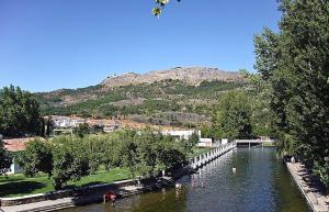 a river with a bridge and a mountain in the background at Casa da Portagem by Portus Alacer in Marvão