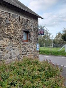 TanisGîte chaleureux avec poêle à granulés的一面有窗户的石头建筑
