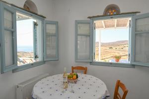 uma mesa com uma tigela de fruta com janelas em Astraia em Agios Ioannis