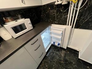 a kitchen with a microwave and an open refrigerator at Yoa apartaments in Deva +6 photos