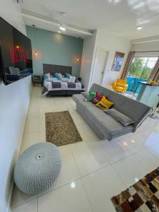 a living room with a couch and a bed at Mangata Loft - Requinte e Conforto para Lazer ou Trabalho in Itanhaém