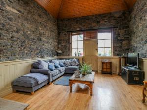 uma sala de estar com um sofá e uma televisão em Coach House em Portlaoise