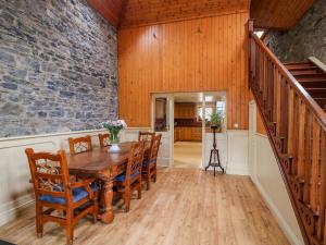 a dining room with a table and chairs and a staircase at Coach House in Portlaoise