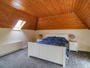 a bedroom with a white bed and a wooden ceiling at Coach House in Portlaoise