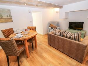 a living room with a couch and a table at Beneath The Beams in Glossop