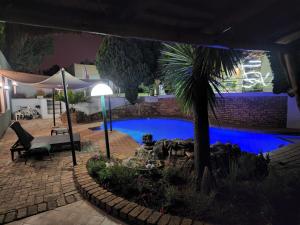 a swimming pool in a yard with a palm tree at Winchester Hotel in Johannesburg