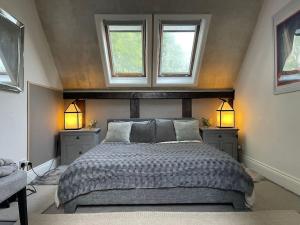 um quarto com uma cama grande e 2 janelas em Stylish 2-bed cottage with secure parking em Winforton