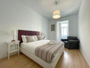 1 dormitorio blanco con 1 cama grande y 1 silla en Dreamy Alameda Apartment, en Lisboa