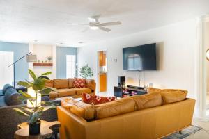 a living room with a couch and a tv at Sunnyside of Life Retreat: Serene 5 BR with pool in Phoenix