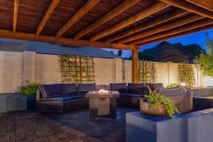 a patio with a couch and a fire pit at Sunnyside of Life Retreat: Serene 5 BR with pool in Phoenix