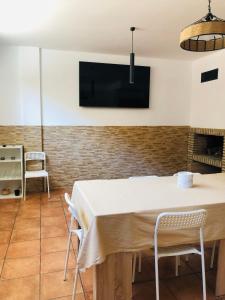 een eetkamer met een tafel en stoelen en een tv bij La Puerta de Viana, con desayuno, piscina y posibilidad Visita a bodega! in Viana