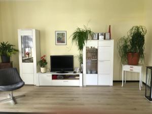 een woonkamer met een wit entertainmentcentrum met een televisie bij Ferienwohnung Bornemann in Goslar