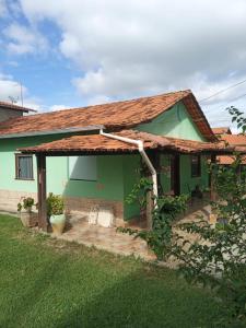 ein kleines grünes Haus mit Dach in der Unterkunft Pousada Capitão Cipoeiro in Serra do Cipo