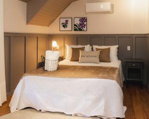 una camera da letto con un grande letto con lenzuola e cuscini bianchi di Natureza Eco Lodge a Vargem Alta