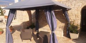 a blue umbrella on a patio with two chairs at Cummersa dell'alba in Locorotondo