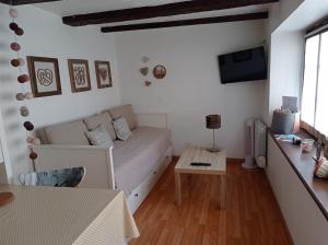 a small living room with a bed and a table at Gîte Cerise & Coquelicot in Epfig