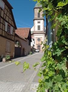 una calle vacía en un pueblo con una torre en Gîte Cerise & Coquelicot, en Epfig