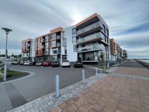 a parking lot with cars parked in front of a building at Naustavör 30 in Reykjavík