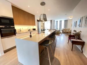 a kitchen with a large white island with bar stools at Naustavör 30 in Reykjavík +11 photos