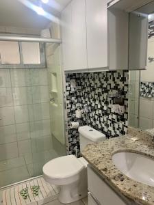 a bathroom with a toilet and a sink at Terrazzo PontaNegra flat Flat Vista Mar Apto 201 in Natal