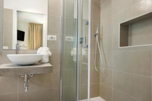ein Badezimmer mit einer Glasdusche mit Waschbecken in der Unterkunft Mercury Beach Hotel in SantʼAntìoco