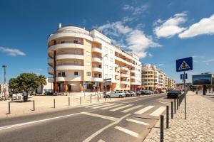 una strada con auto parcheggiate davanti a un edificio di The View - Sea, Surf and Lisbon a Costa da Caparica