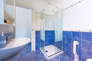 a bathroom with a glass shower and a sink at sole chiaro home in Procida