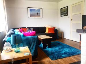 un soggiorno con divano e tappeto blu di Sea Bean 2 Bedroom House Manorbier Tenby Pet Friendly a Manorbier