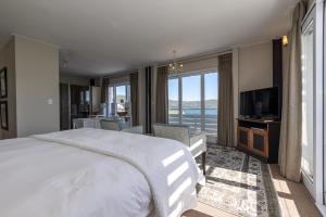 una camera da letto con un letto grande e una televisione di The Lofts Boutique Hotel a Knysna