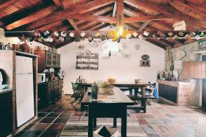 a kitchen with wooden ceilings and tables in a room at Casa do Professor in Casais dos Monizes