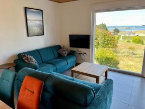 a living room with a blue couch and a table at Ty Koad in Lanmodez