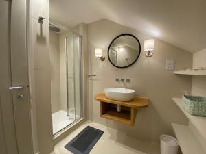 a bathroom with a sink and a shower with a mirror at Linhay Cottages in Box