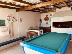 a kitchen with a pool table in a room at Pousada Caminho do Mar MADHOUZE in Garopaba