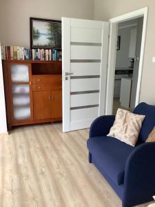 sala de estar con sofá azul y estante para libros en Villa Klif 10, en Trzęsacz 4 fotos más