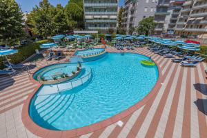 a large swimming pool with chairs and umbrellas at Hotel Smeraldo in Cesenatico