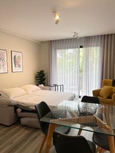 uma sala de estar com uma cama e uma mesa de vidro em Dona I Apartments at Botanical Garden em Funchal